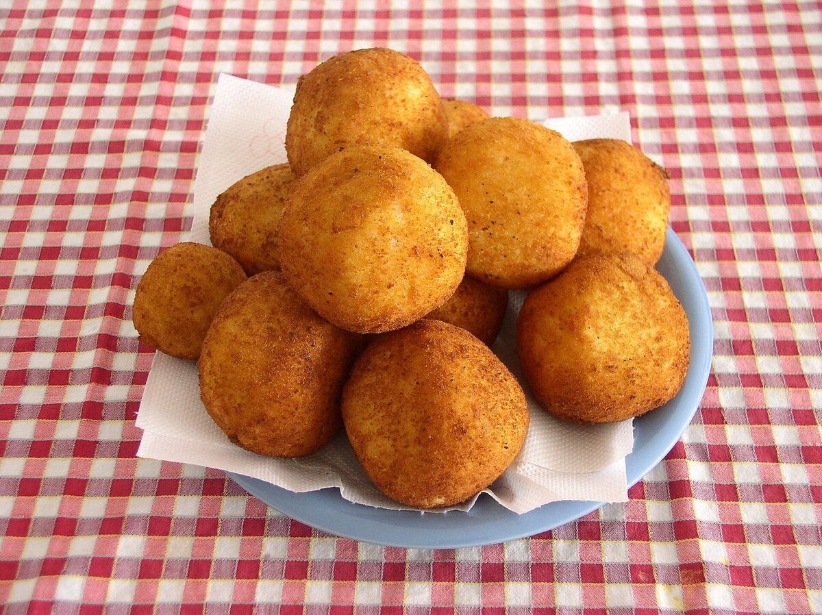 A plate of fried arancini, the street-food symbol of Catania