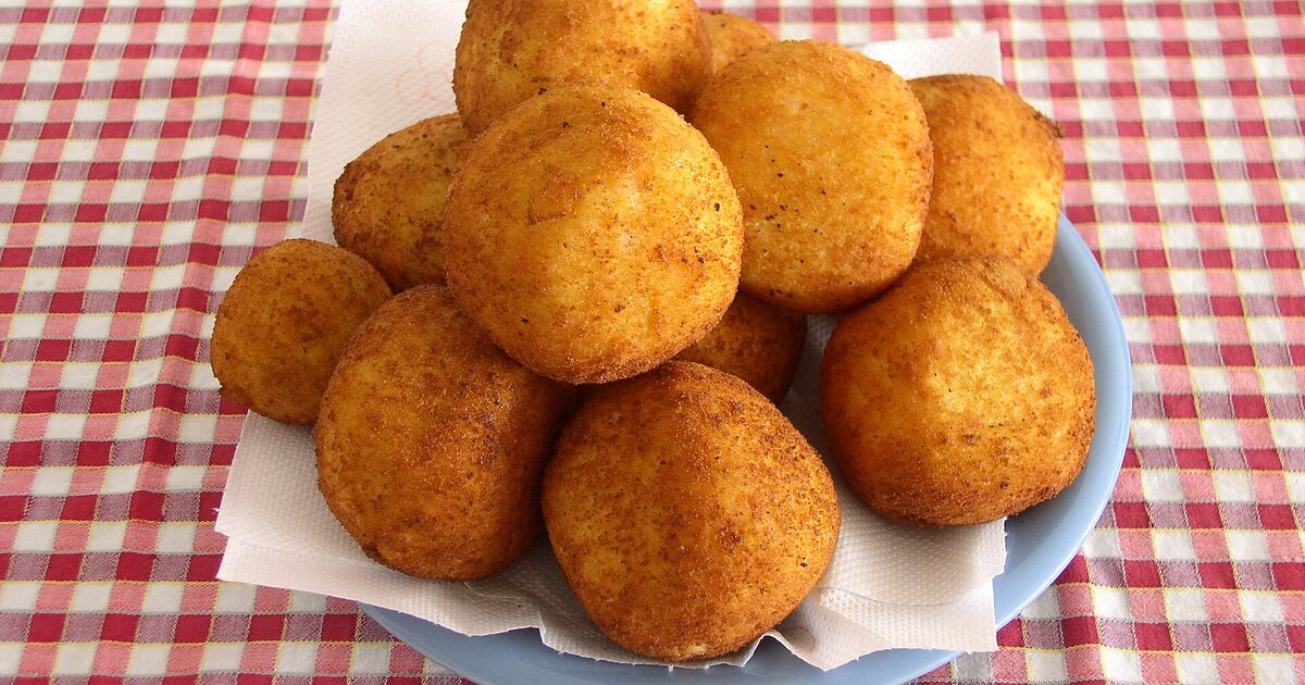 A plate of fried arancini, the street-food symbol of Catania